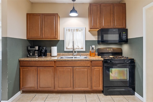 kitchen featuring a sink, hanging light fixtures, light countertops, brown cabinetry, and black appliances