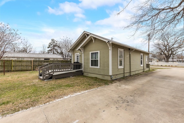 view of home's exterior featuring fence, a wooden deck, crawl space, a lawn, and concrete driveway