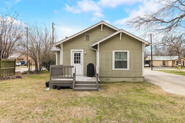 back of property with a lawn and crawl space