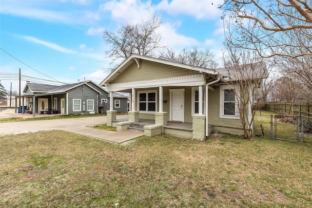 bungalow-style house with fence, a gate, covered porch, and a front yard