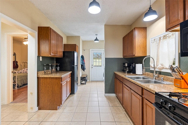 kitchen featuring a sink, light tile patterned floors, hanging light fixtures, light countertops, and brown cabinetry