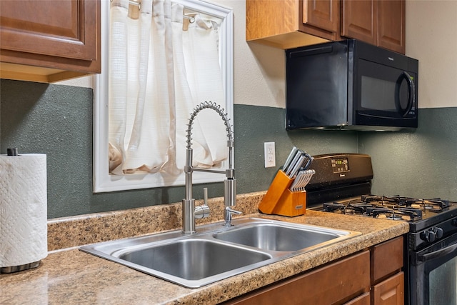 kitchen with a textured wall, black appliances, and brown cabinetry