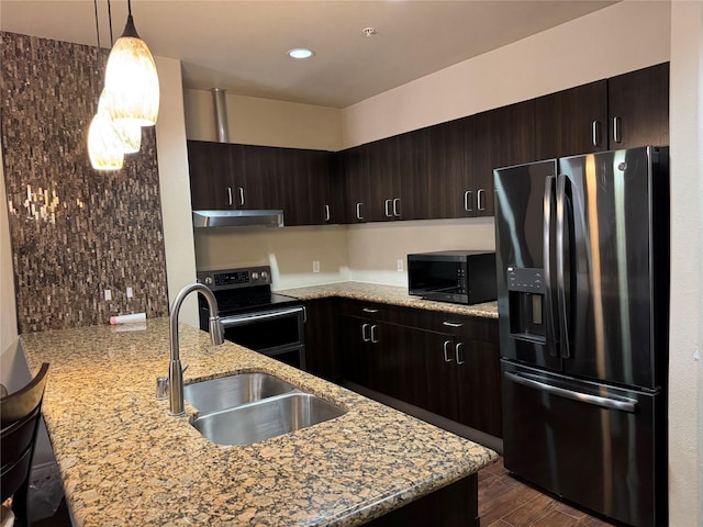 kitchen with dark brown cabinetry, a peninsula, under cabinet range hood, black appliances, and a sink