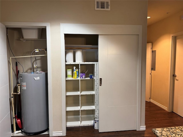 utility room featuring electric panel, water heater, and visible vents