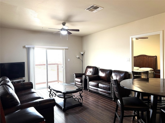 living area featuring dark wood finished floors, visible vents, and a ceiling fan