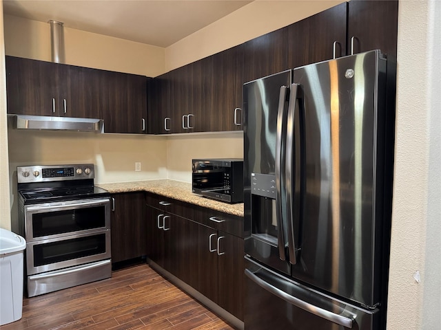 kitchen featuring black appliances, dark brown cabinets, dark wood finished floors, and under cabinet range hood