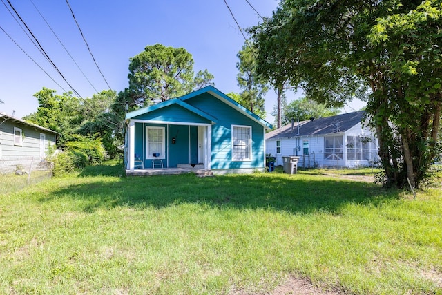 bungalow featuring a porch and a front lawn