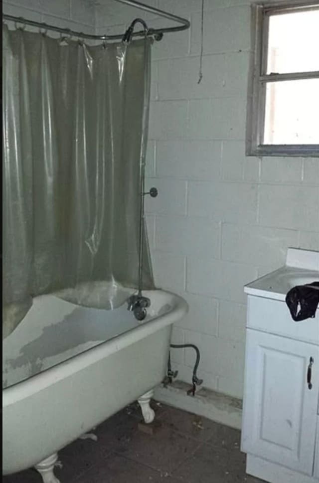 bathroom featuring shower / bathtub combination with curtain and vanity