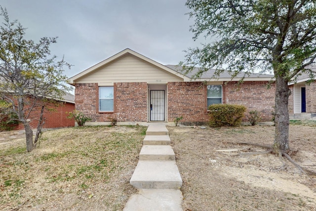 single story home featuring brick siding