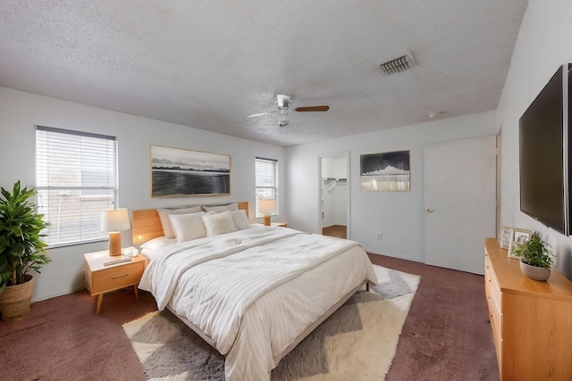 bedroom with dark colored carpet, multiple windows, and visible vents