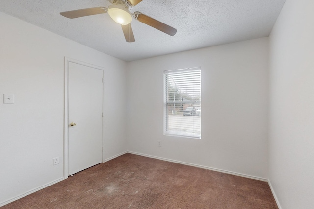 empty room featuring carpet floors, ceiling fan, a textured ceiling, and baseboards