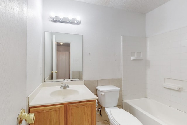 full bathroom with tub / shower combination, vanity, toilet, and a textured ceiling