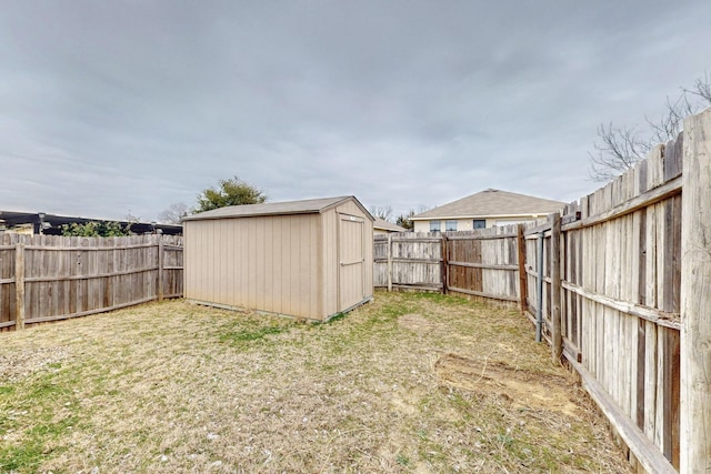 view of yard with a storage shed, an outdoor structure, and a fenced backyard