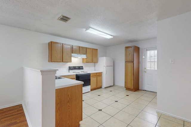 kitchen with brown cabinets, visible vents, light countertops, white appliances, and under cabinet range hood