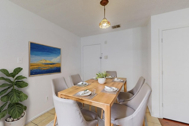 dining room featuring light tile patterned floors, baseboards, and visible vents