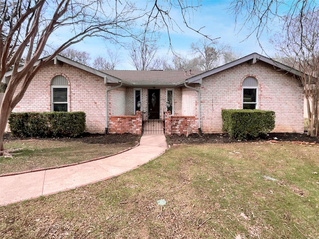 ranch-style home with brick siding and a front yard