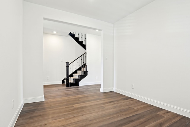 2321 Wellington Ln, Corinth, TX 76210 - empty room with stairway, wood finished floors, baseboards, and lofted ceiling