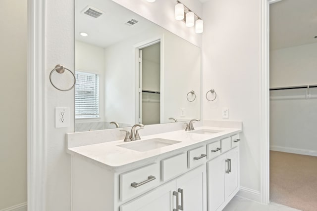 2321 Wellington Ln, Corinth, TX 76210 - bathroom with a walk in closet, double vanity, and baseboards