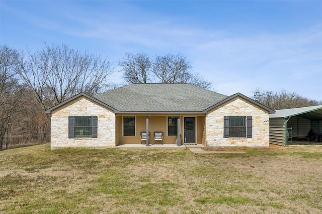 ranch-style home with a carport, a shingled roof, a front yard, and stone siding