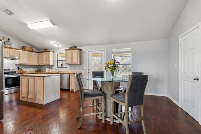 kitchen featuring under cabinet range hood, visible vents, vaulted ceiling, appliances with stainless steel finishes, and light brown cabinetry