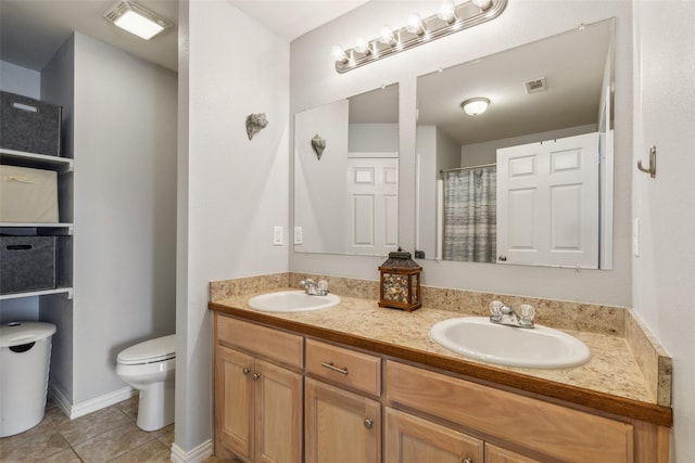 full bath with double vanity, a sink, toilet, and tile patterned floors