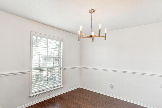 unfurnished room featuring a chandelier and dark wood-type flooring