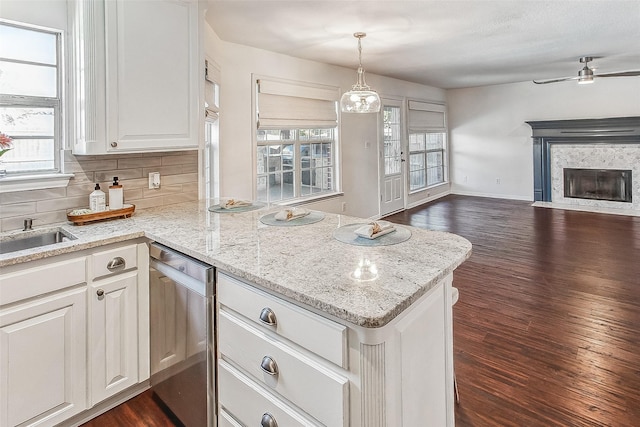 kitchen with dark hardwood / wood-style flooring, kitchen peninsula, pendant lighting, and white cabinets