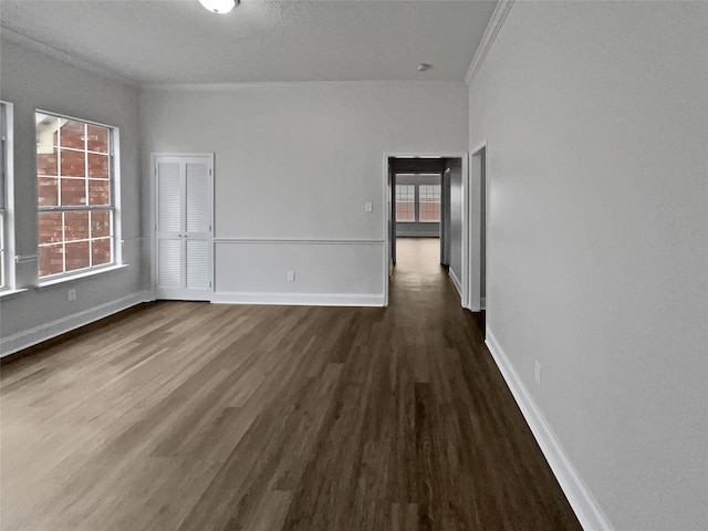 empty room featuring crown molding and dark hardwood / wood-style floors