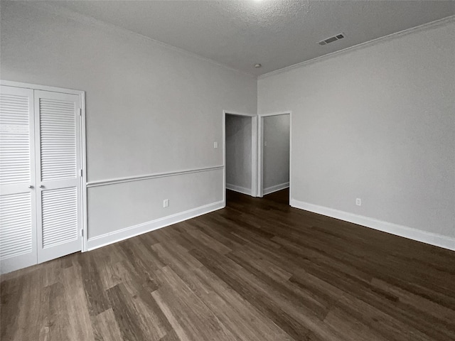 unfurnished bedroom featuring a textured ceiling and dark wood-type flooring