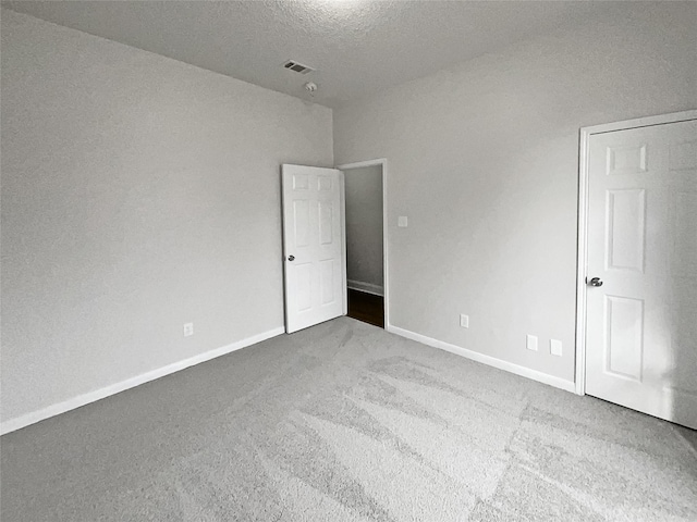 unfurnished bedroom with a textured ceiling and carpet flooring