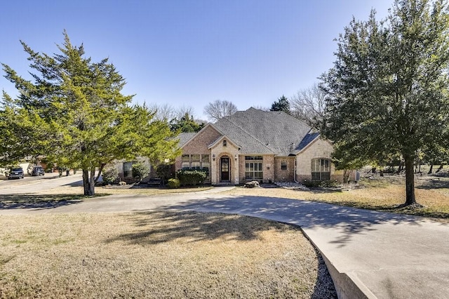 french country style house featuring a front lawn