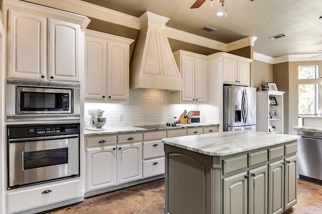 kitchen with appliances with stainless steel finishes, ceiling fan, a kitchen island, and custom exhaust hood