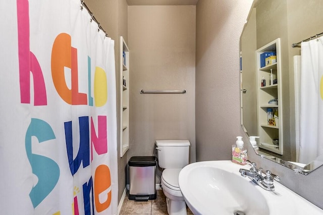 bathroom with sink, toilet, and tile patterned floors