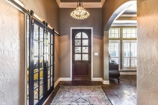 foyer with crown molding and a barn door