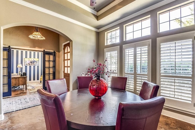 dining area with a barn door and crown molding