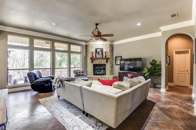 living room with a fireplace, ornamental molding, and ceiling fan