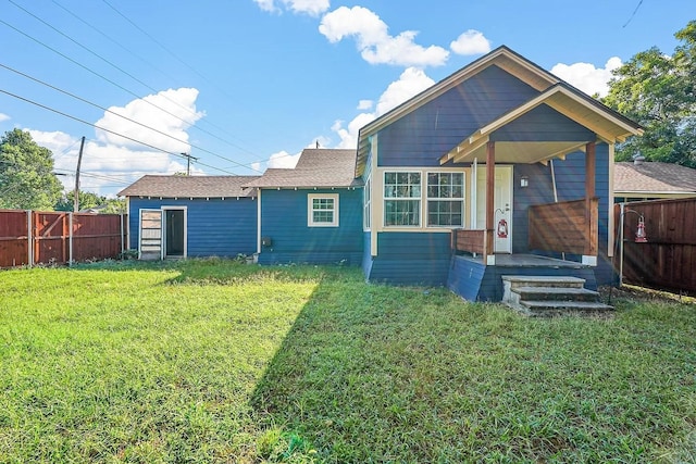 rear view of property featuring a lawn