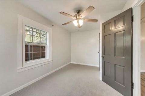 carpeted empty room featuring ceiling fan