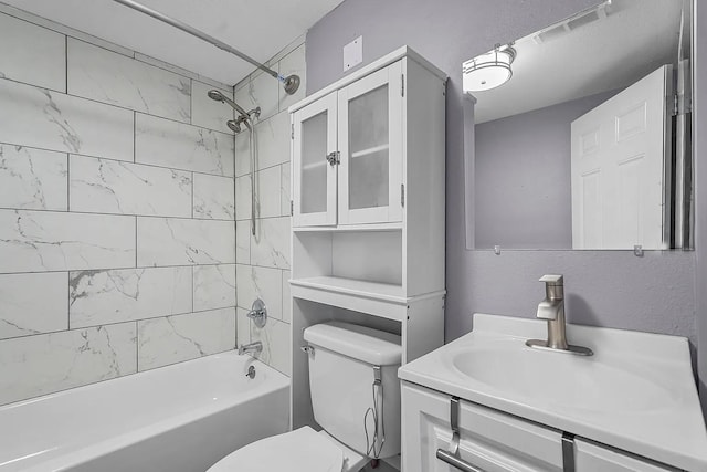 full bathroom with tiled shower / bath combo, vanity, and toilet