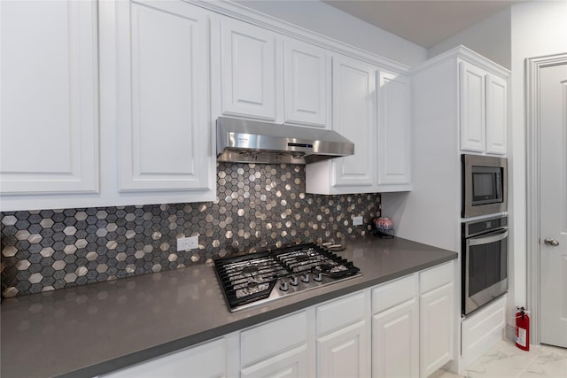 kitchen with appliances with stainless steel finishes, tasteful backsplash, and white cabinets