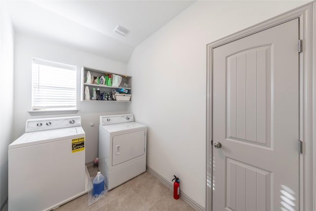 laundry room featuring washing machine and dryer and light tile patterned floors