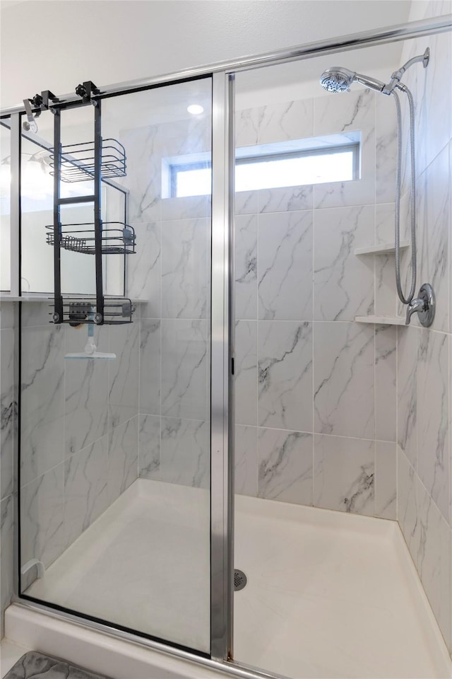 bathroom featuring a shower with door