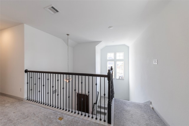 corridor featuring lofted ceiling and carpet flooring