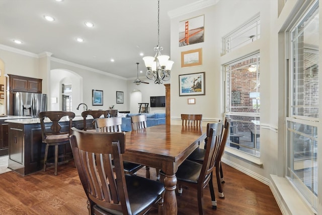 dining room featuring arched walkways, ornamental molding, a notable chandelier, and dark wood finished floors
