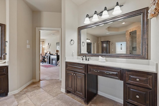 bathroom with tile patterned floors, baseboards, and vanity
