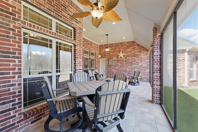 sunroom featuring outdoor dining area and a ceiling fan
