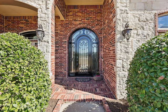 doorway to property with brick siding and stone siding