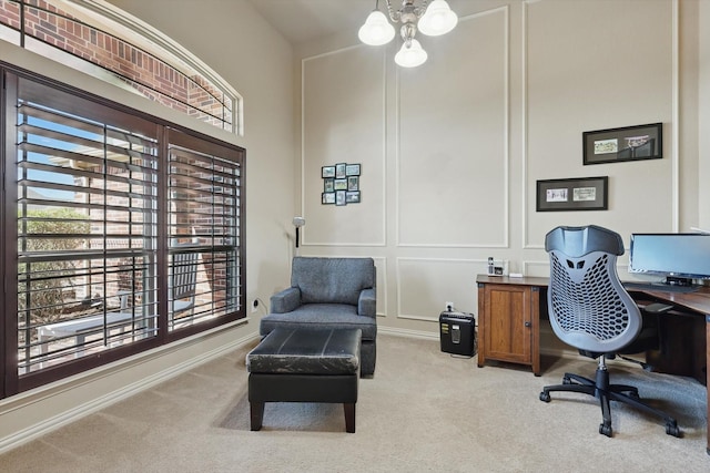 carpeted home office with a decorative wall and an inviting chandelier