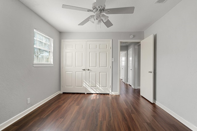 unfurnished bedroom featuring ceiling fan, a closet, and dark hardwood / wood-style flooring