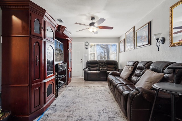 living room with light hardwood / wood-style flooring and ceiling fan